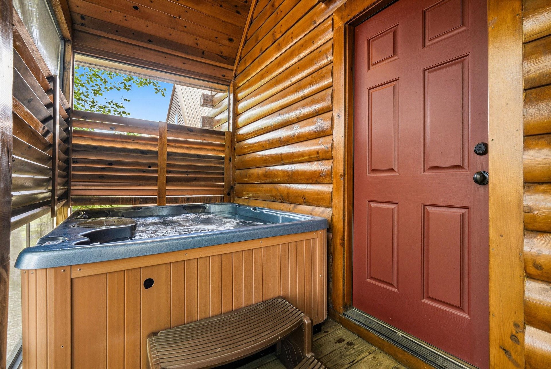 Soak in your private hot tub surrounded by warm log walls and rustic privacy screens, creating the perfect mountain retreat.