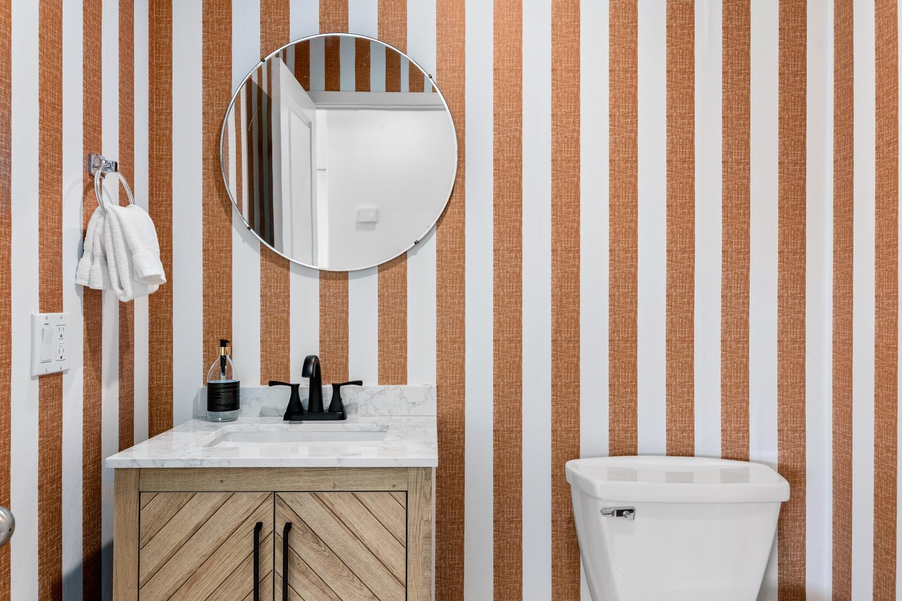 Stylish halfbath with bold striped wallpaper