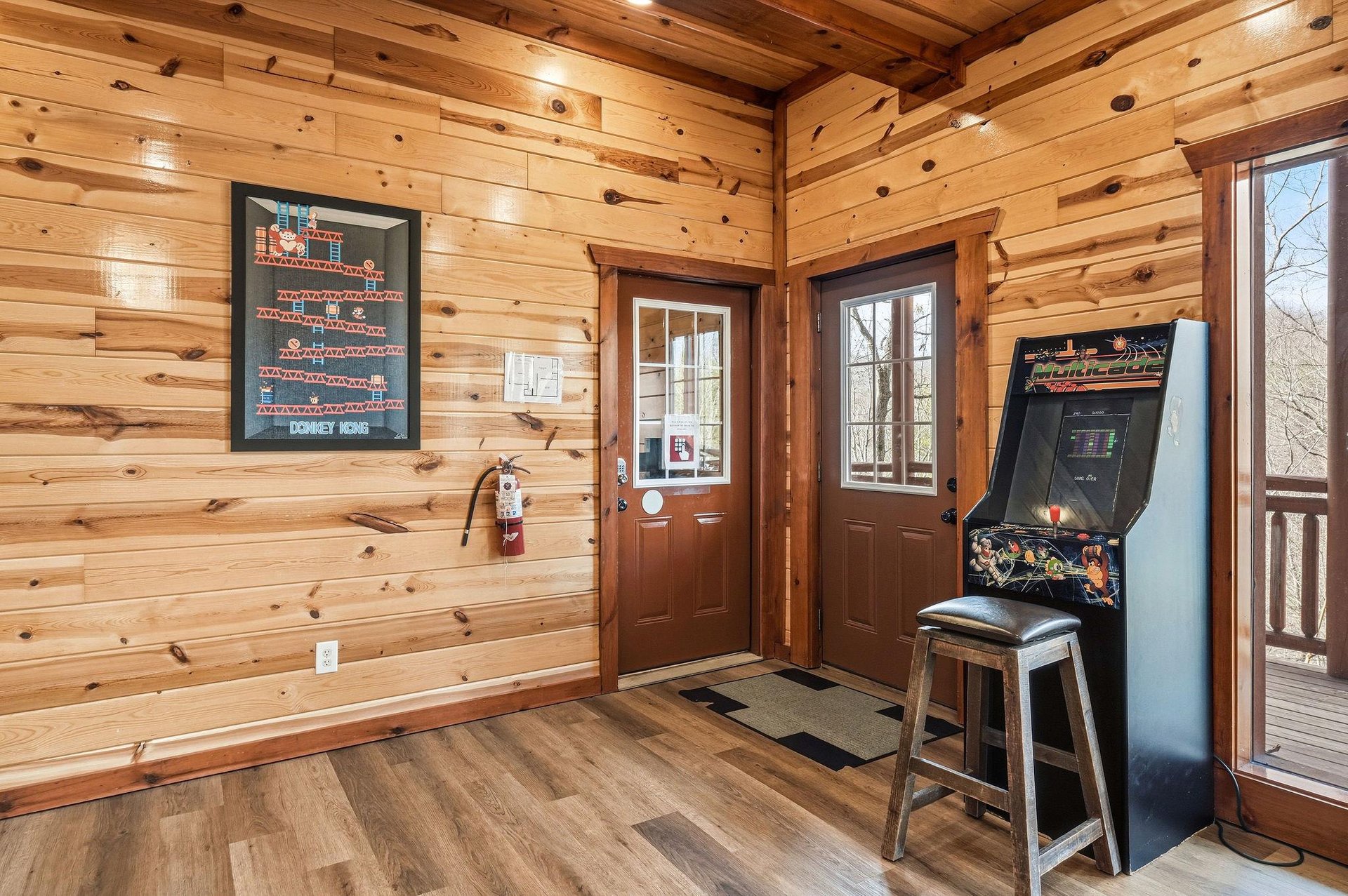 Step into your cozy game room featuring warm wood walls and vintage arcade fun—perfect for unwinding after mountain adventures.