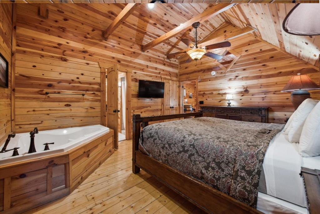 Step into your rustic retreat where warm wood surrounds you completely. Sink into the king bed or unwind in your private jetted tub beneath exposed beams.