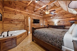Step into your rustic retreat where warm wood surrounds you completely. Sink into the king bed or unwind in your private jetted tub beneath exposed beams.