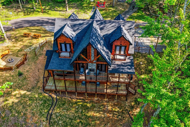Stunning log cabin retreat nestled among towering trees, featuring wraparound decks perfect for morning coffee and evening relaxation.