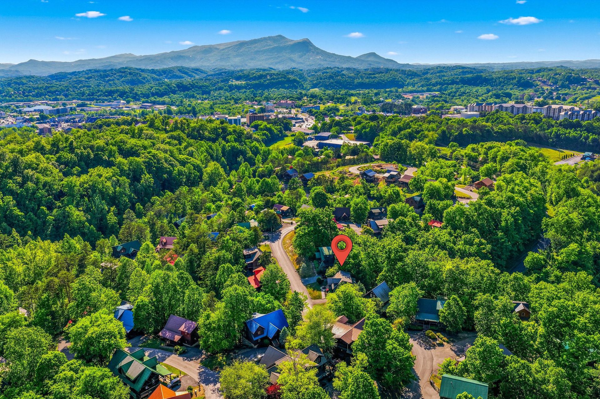 Aerial view showcasing the propertys location within a scenic mountain community, surrounded by lush forests and rolling peaks.