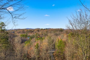 Expansive mountain views stretch across rolling hills dotted with homes, showcasing the natural beauty surrounding the property.