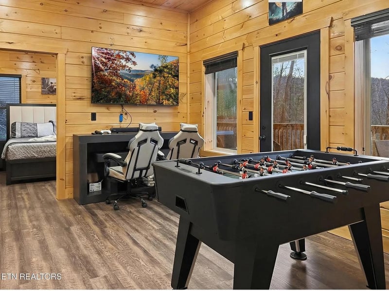 Challenge friends to foosball in your game room, then unwind with gaming chairs and bigscreen entertainment in this cozy cabin retreat.