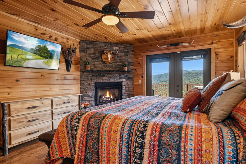 Curl up under soft linens and wake to mountain views through your private balcony doors, with a cozy fireplace and flatscreen TV creating your perfect retreat.