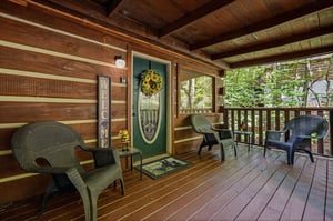 A warm welcome awaits on your private covered porch, where you can settle into cozy wicker seating surrounded by peaceful wooded views and fresh mountain air.
