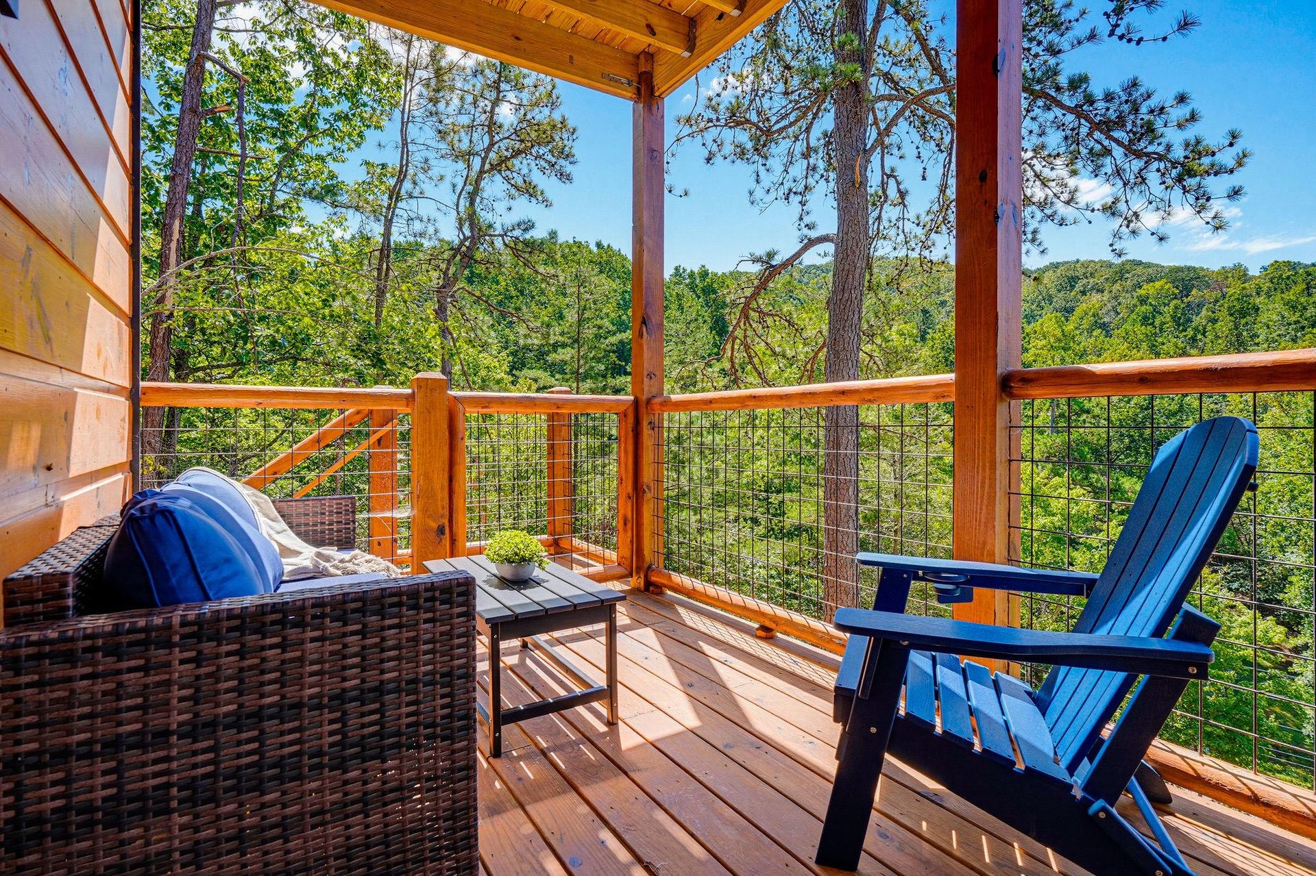 A covered deck framed by towering trees offers lush forest views and inviting seating to unwind in peaceful mountain tranquility.