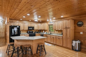 Cook memorable meals in this spacious rustic kitchen featuring granite counters, full appliances, and a welcoming island with bar seating.