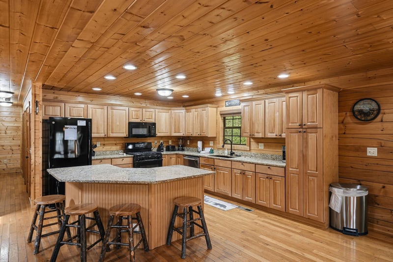 Cook memorable meals in this spacious rustic kitchen featuring granite counters, full appliances, and a welcoming island with bar seating.