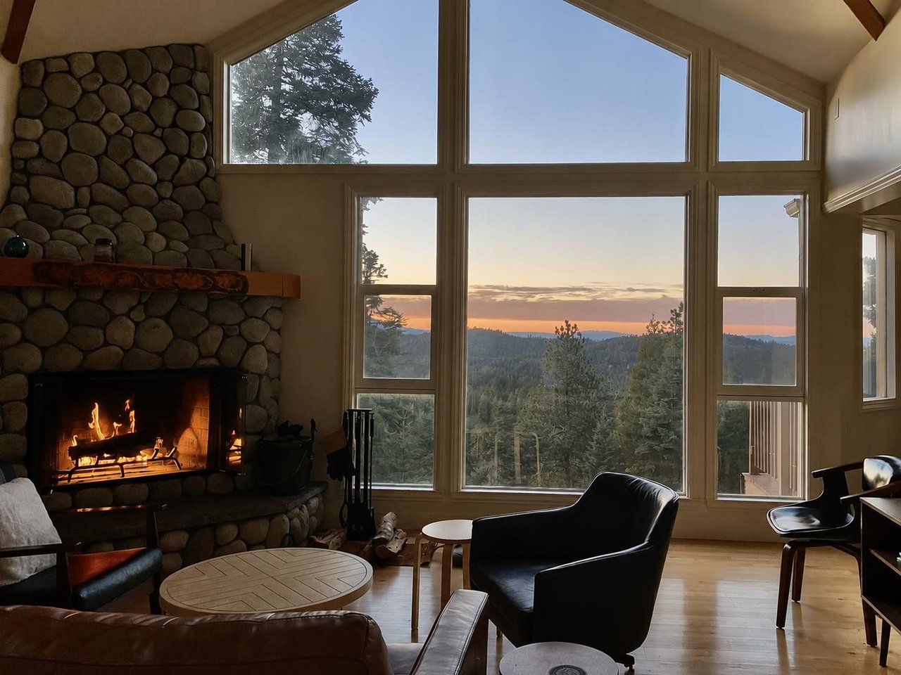 Large stone fireplace, ample seating, and easy access to the kitchen and dining area.