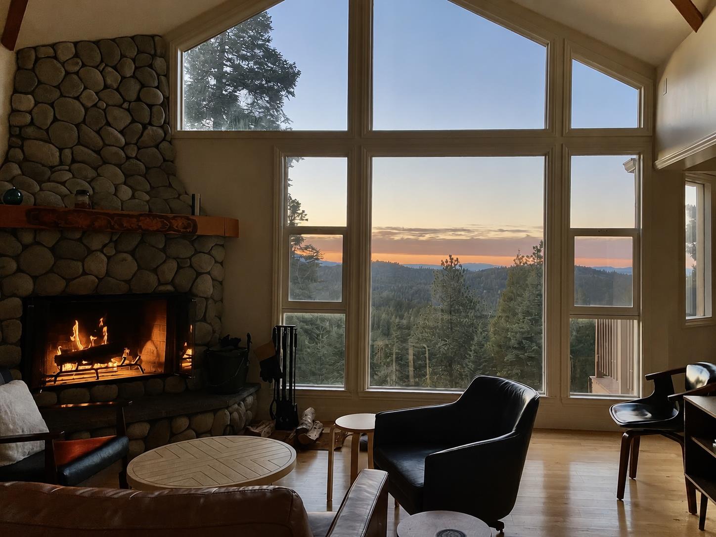 Large stone fireplace, ample seating, and easy access to the kitchen and dining area.