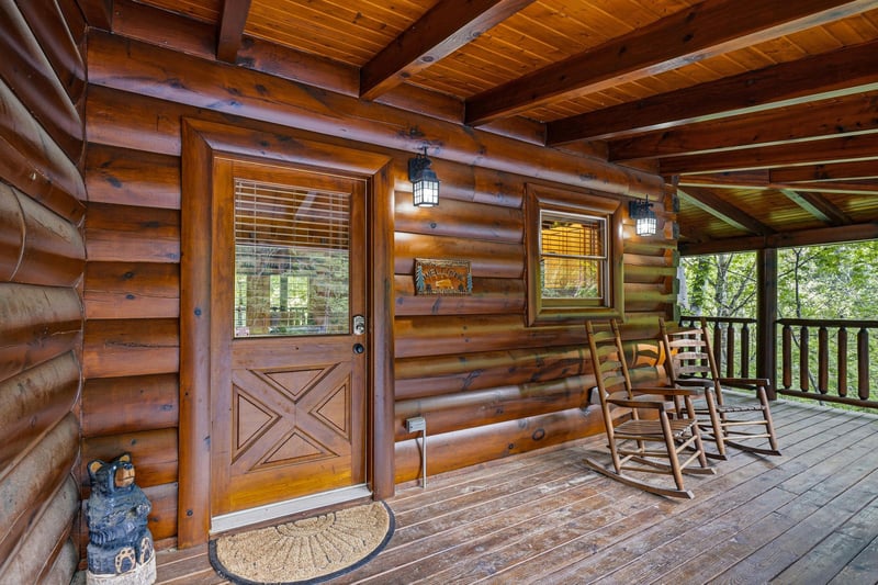 Settle into your private rocking chairs on this covered porch, where rustic charm meets forest tranquility for perfect morning coffee moments.