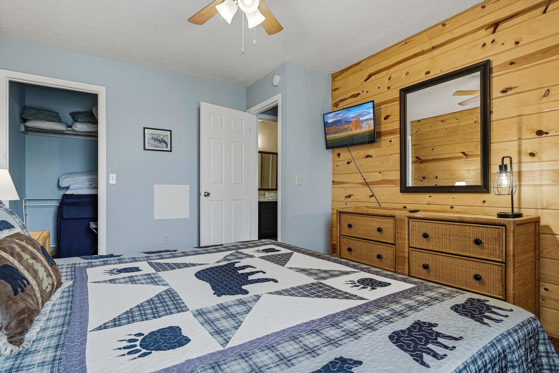 Cozy bedroom with rustic wood accents, plenty of storage, and charming bearthemed bedding for your mountain getaway.