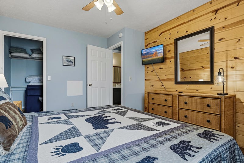 Cozy bedroom with rustic wood accents, plenty of storage, and charming bearthemed bedding for your mountain getaway.
