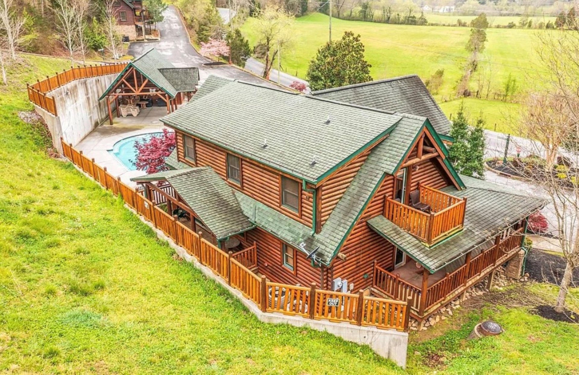 Stunning log cabin retreat surrounded by rolling green fields and peaceful countryside setting.