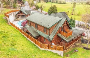 Stunning log cabin retreat surrounded by rolling green fields and peaceful countryside setting.