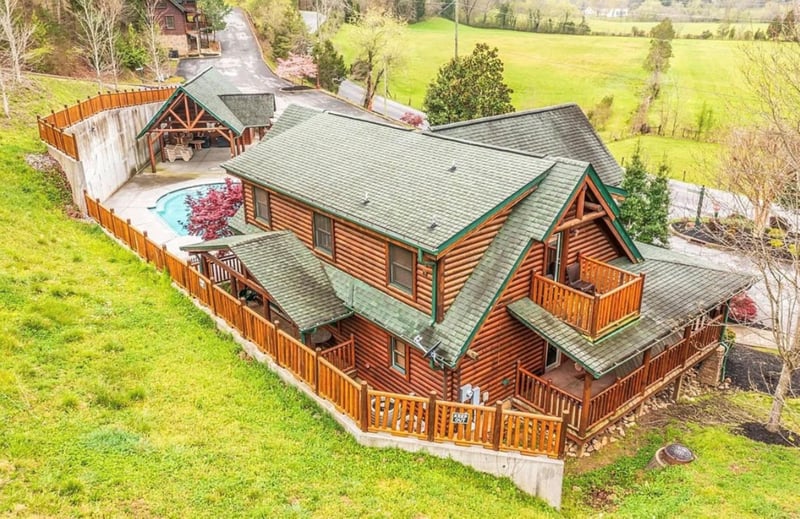 Stunning log cabin retreat surrounded by rolling green fields and peaceful countryside setting.