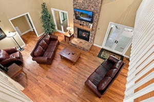 Relax in your spacious living room, where rich leather seating faces a stone fireplace and soaring ceilings create an inviting, open retreat for unwinding after your mountain adventures.