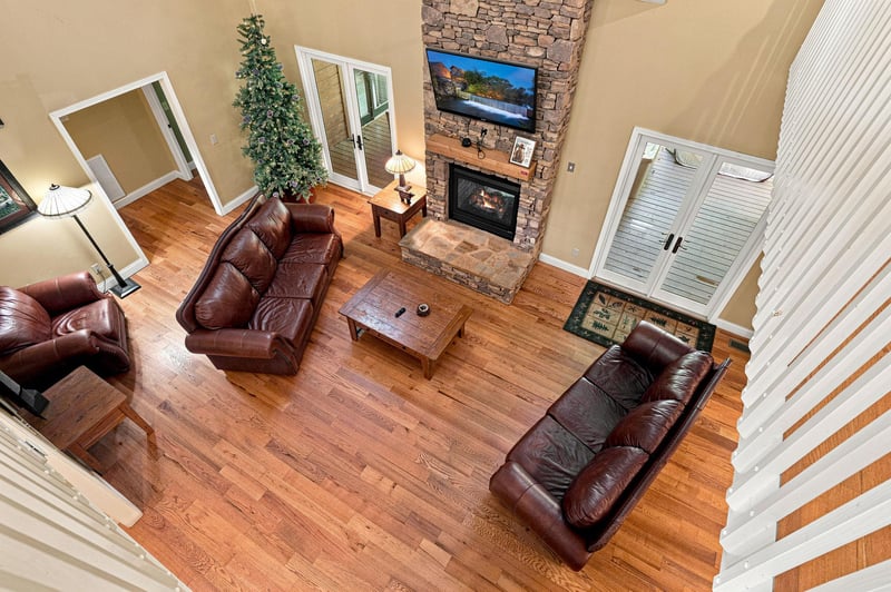 Relax in your spacious living room, where rich leather seating faces a stone fireplace and soaring ceilings create an inviting, open retreat for unwinding after your mountain adventures.