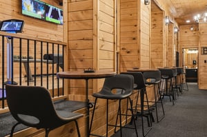 Settle into your own private perch at the barheight seating, where rustic wood and modern design meet beneath warm lighting—perfect for chatting, gaming, or simply unwinding with a drink.