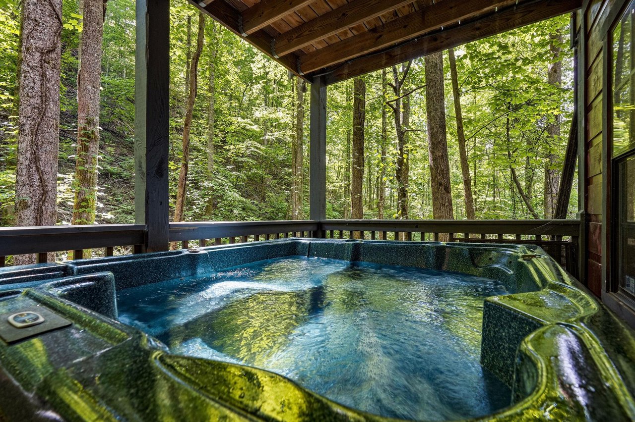 Sink into your private hot tub and let the peaceful forest surround you—pure relaxation awaits on your covered deck.