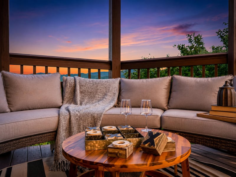 Sunset paints the sky in soft pastels as you relax on your private balcony, wine in hand, surrounded by plush seating and serene mountain views.