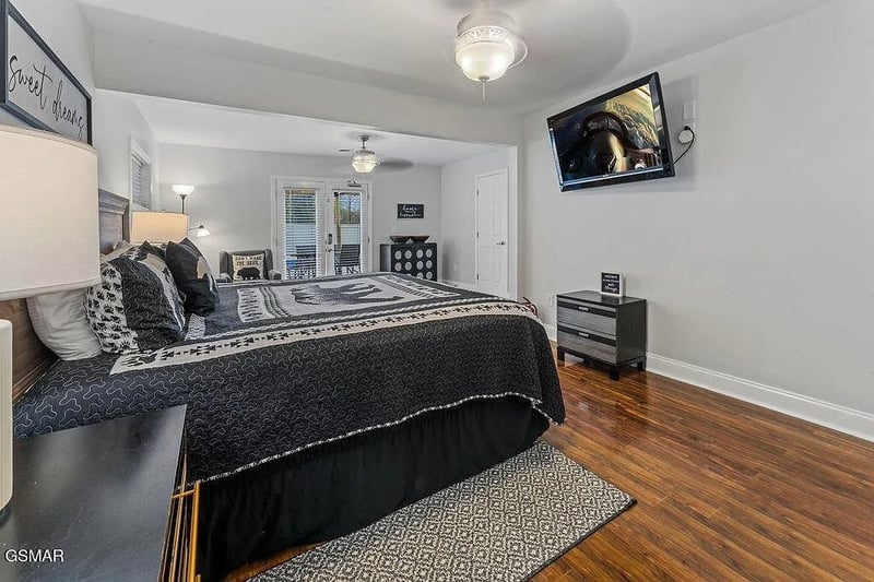 Unwind in your stylish bedroom with patterned bedding, warm hardwood floors, and entertainment at your fingertips.