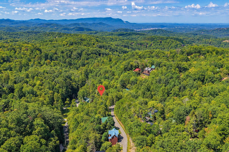 Aerial view of the property nestled in a lush mountain landscape, offering serene seclusion and natural beauty in a forested setting.
