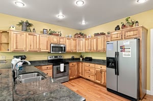 Step into this spacious kitchen equipped with modern stainless steel appliances, granite countertops, and warm wood cabinetry—all the comforts you need to prepare your favorite meals during your stay.