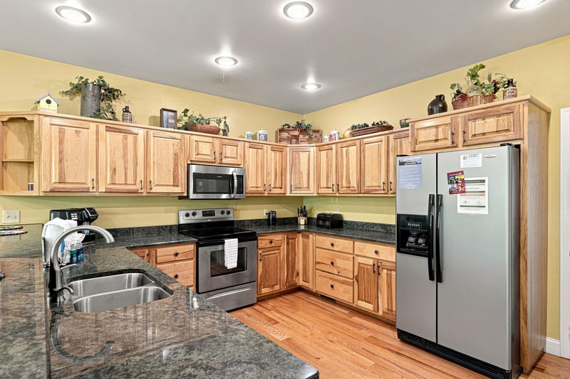 Step into this spacious kitchen equipped with modern stainless steel appliances, granite countertops, and warm wood cabinetry—all the comforts you need to prepare your favorite meals during your stay.