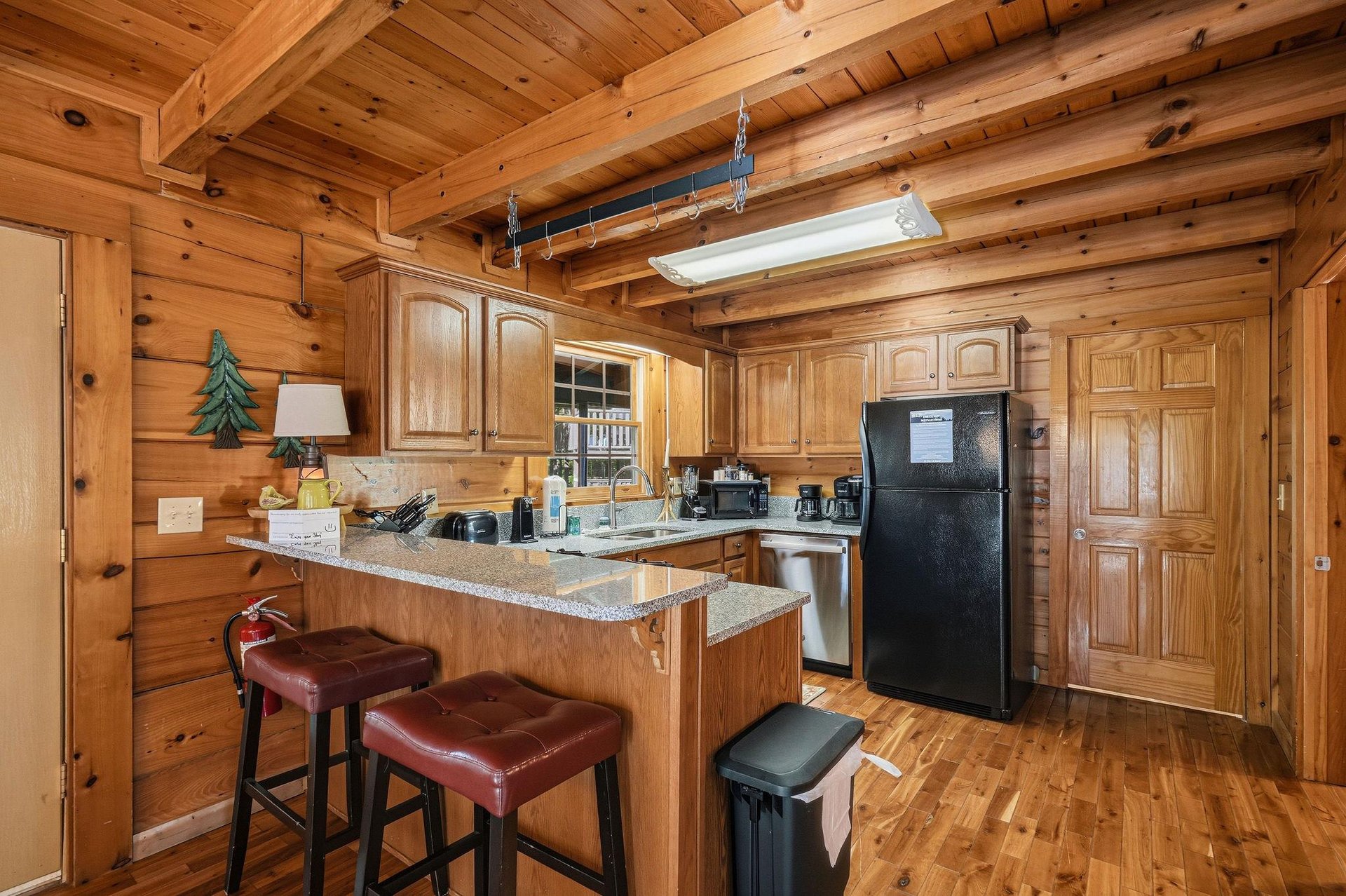 Cook your favorite meals in this fully equipped log cabin kitchen with granite counters and breakfast bar seating.