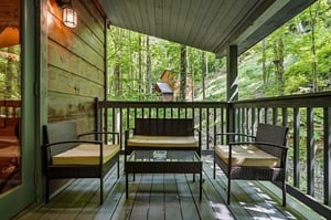 Step onto your private covered balcony, where comfortable seating invites you to unwind amid peaceful forest views and fresh mountain air.