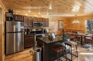 Gather around this spacious kitchen island where youll prepare meals together, surrounded by warm wood beams and modern appliances.