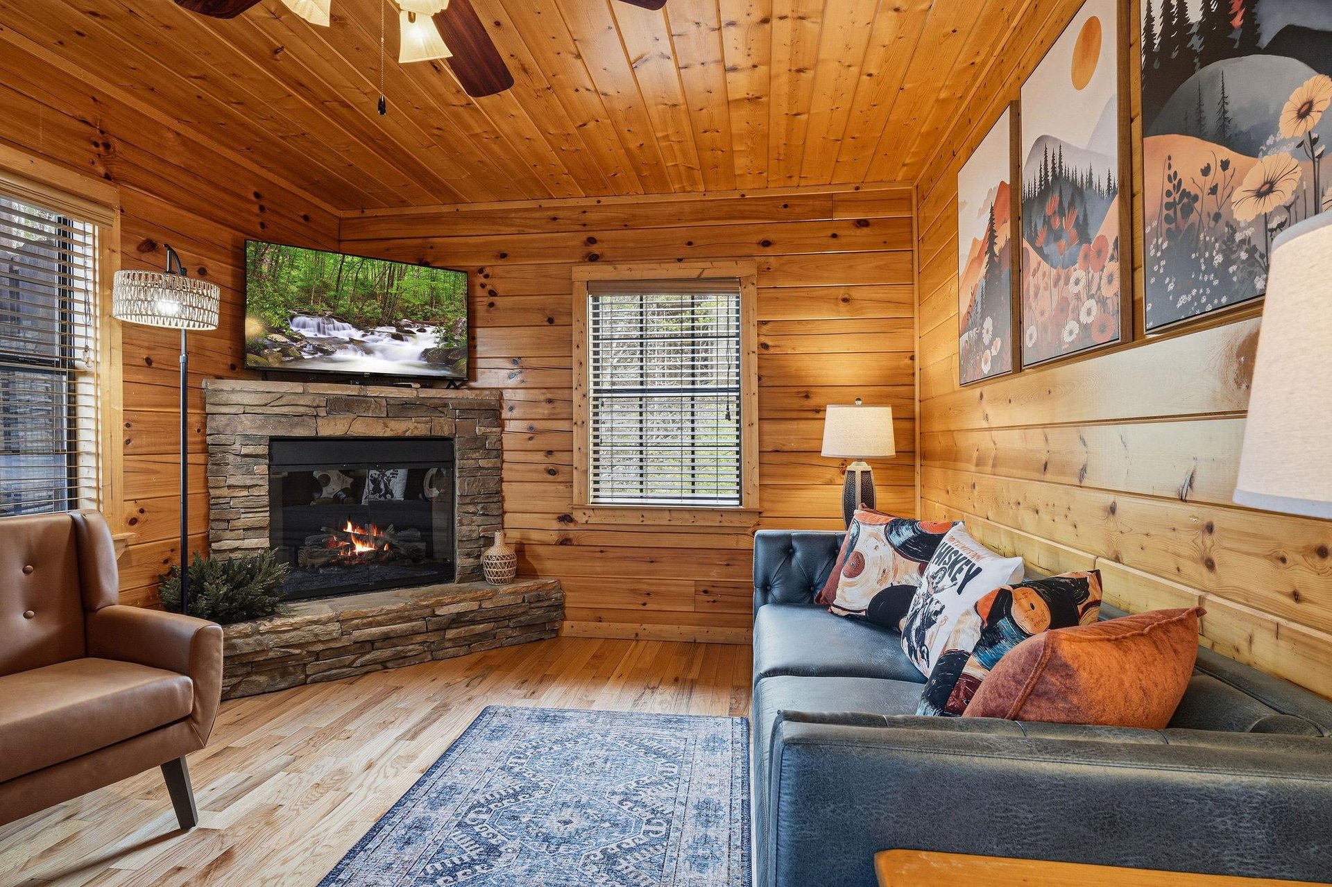 Sink into the cozy sectional sofa while the stone fireplace crackles warmly, creating your perfect cabin retreat.