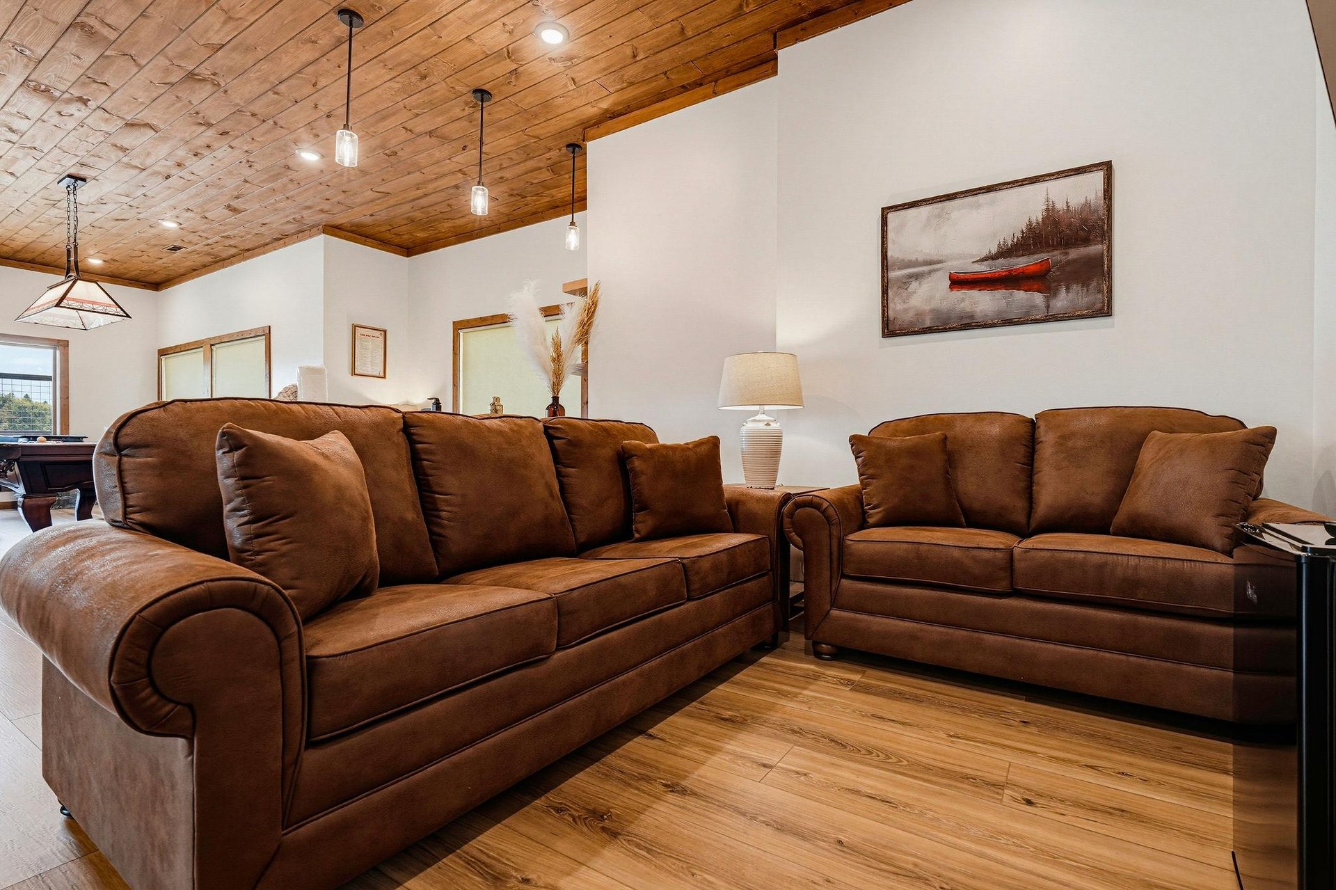 Sink into plush brown leather sofas beneath warm woodplanked ceilings—your perfect spot to unwind after a day of adventure.