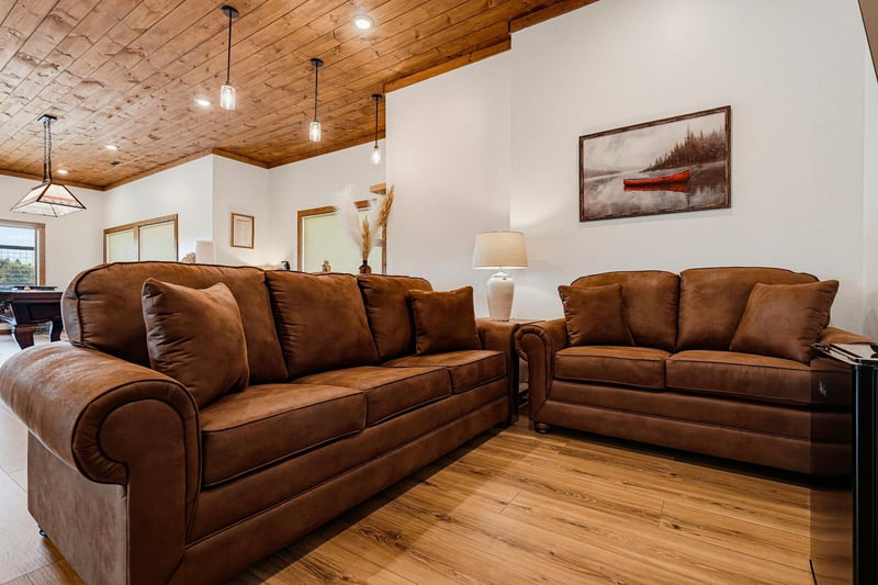 Sink into plush brown leather sofas beneath warm woodplanked ceilings—your perfect spot to unwind after a day of adventure.