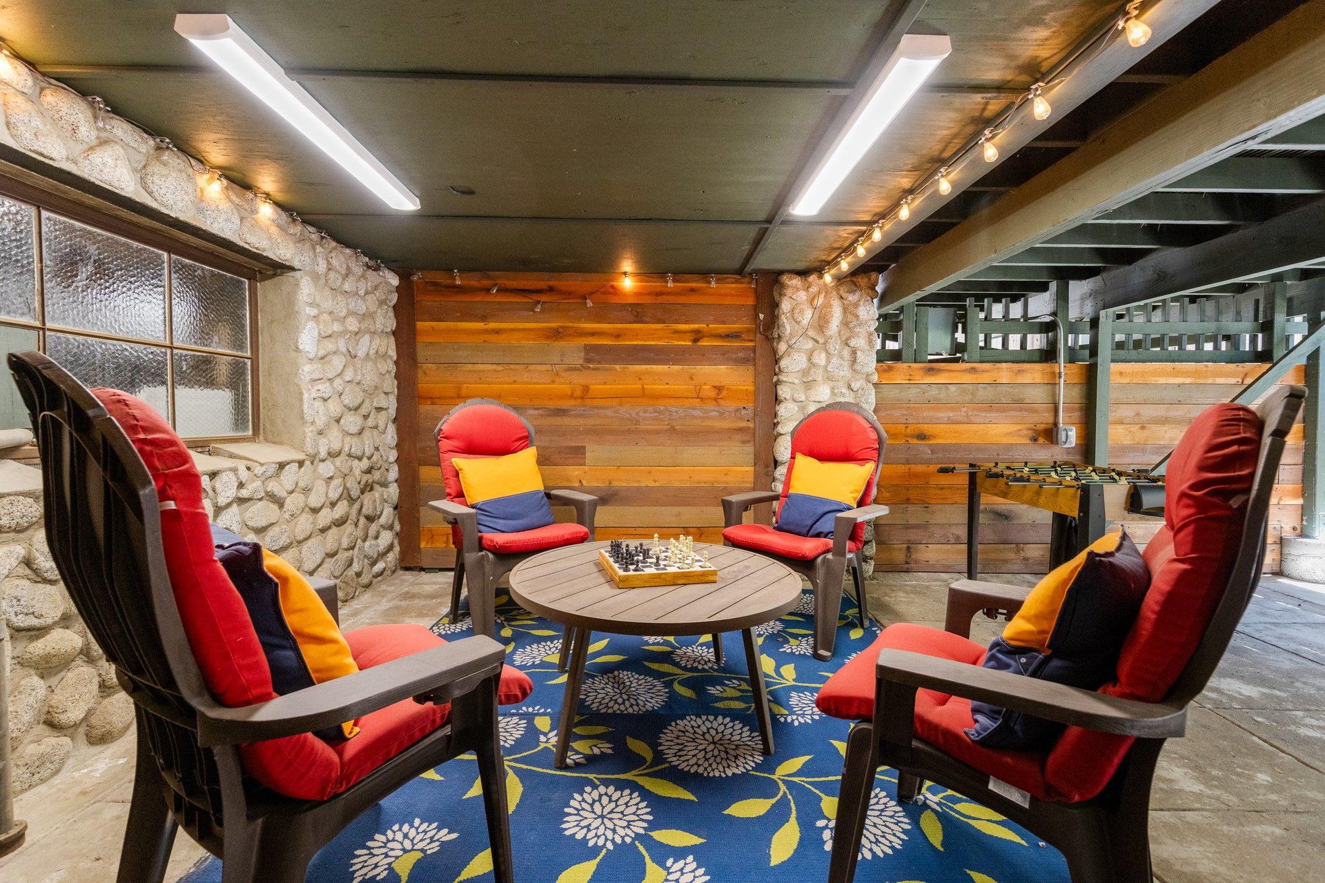 Below the deck is another outdoor seating area with games.
