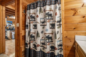 Step into your cozy, rusticthemed bathroom with charming woodlandinspired details. The warm pine walls and naturethemed shower curtain create a cabinlike retreat perfect for unwinding after your a