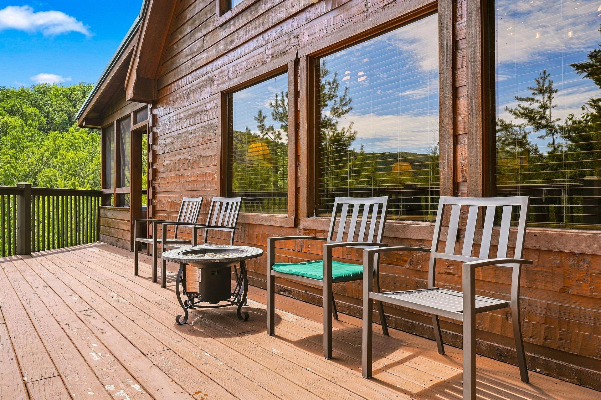 This inviting deck offers comfortable seating where you can unwind and take in the surrounding natural beauty through expansive windows that frame the lush greenery beyond.