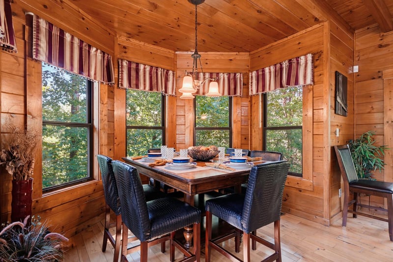 Gather around this handsome dining table, where warm wood and forest views create the perfect setting for your morning coffee or evening meal.