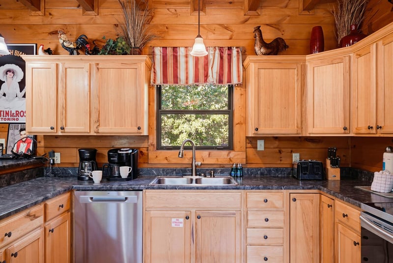 A fully equipped country kitchen awaits, featuring warm wood cabinets, modern appliances, and charming rustic touches. Perfect for preparing your morning coffee or a homecooked meal during your stay.
