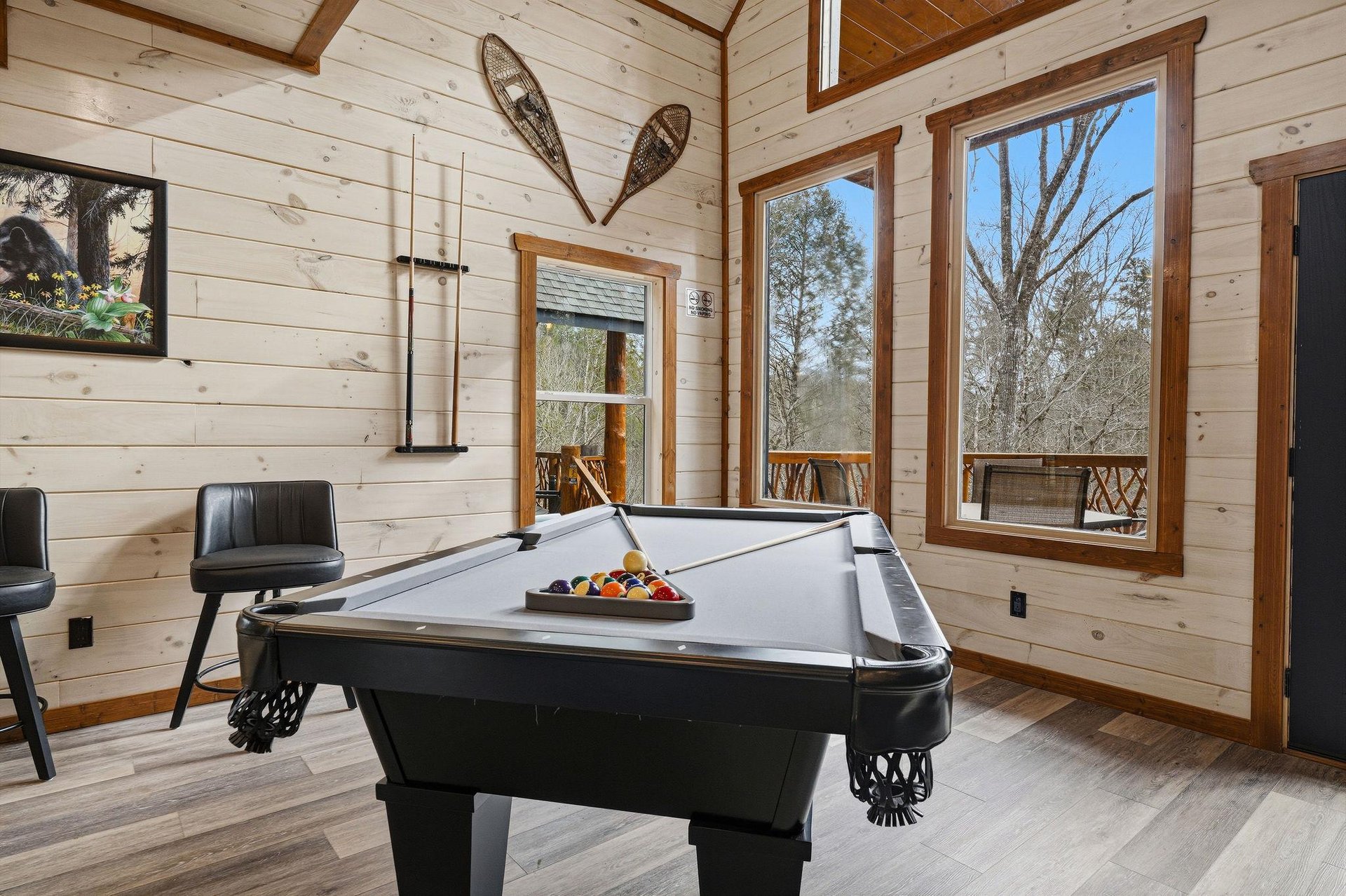 Your game room retreat awaits with a premium pool table, rustic charm, and nature views through every window.