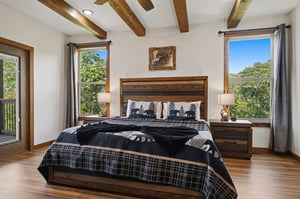 Drift off beneath rustic wooden beams as natural light streams through your windows, framing peaceful treetop views that greet you each morning.