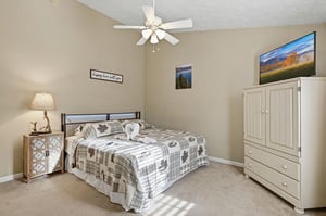 Your comfortable bedroom features rustic charm with naturethemed decor, a ceiling fan for cool nights, and entertainment center for relaxing evenings.