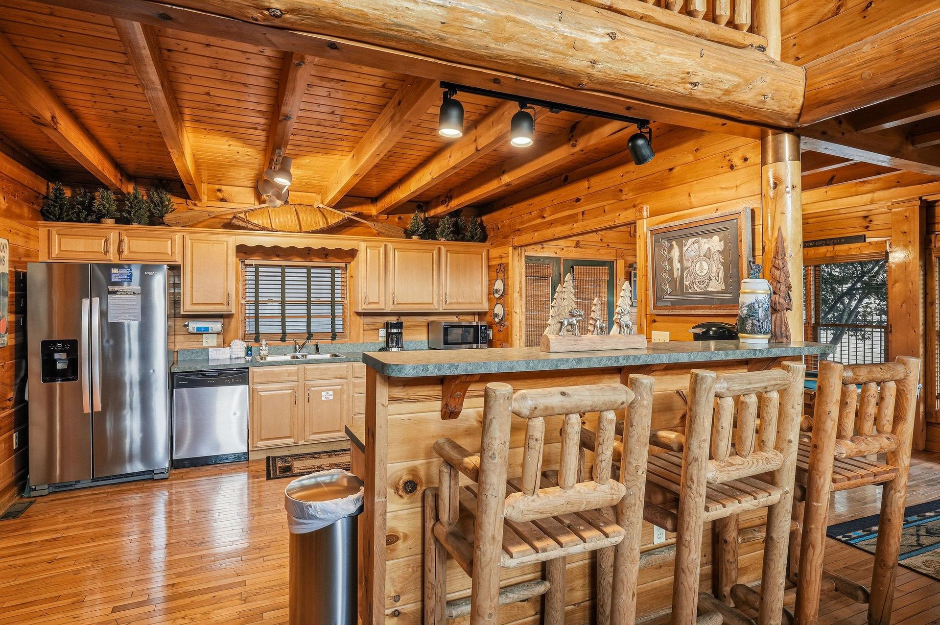 Step into your cozy mountain retreat where rustic log beams frame a fullyequipped kitchen with modern stainless appliances. Gather around the handcrafted log bar stools for meals and memories.