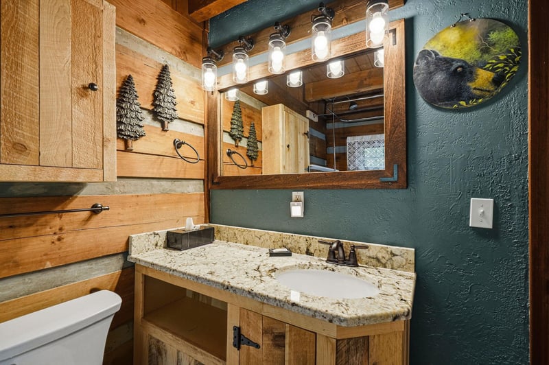 Step into your private bathroom featuring rustic wood accents, granite countertops, and charming cabininspired décor that brings mountain serenity to your morning routine.