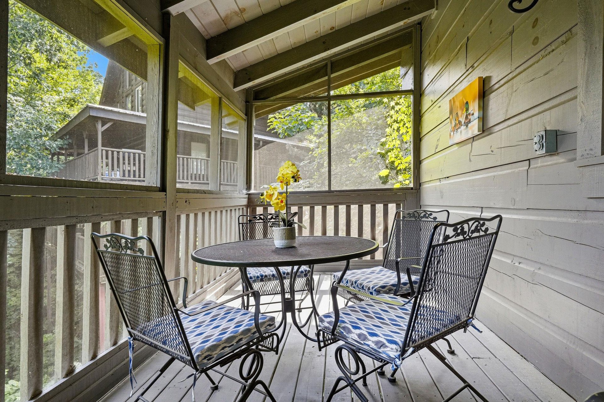 Your private screened porch invites quiet mornings with coffee and fresh mountain air. Settle into cushioned chairs, listen to the trees, and unwind in your peaceful wooded retreat.