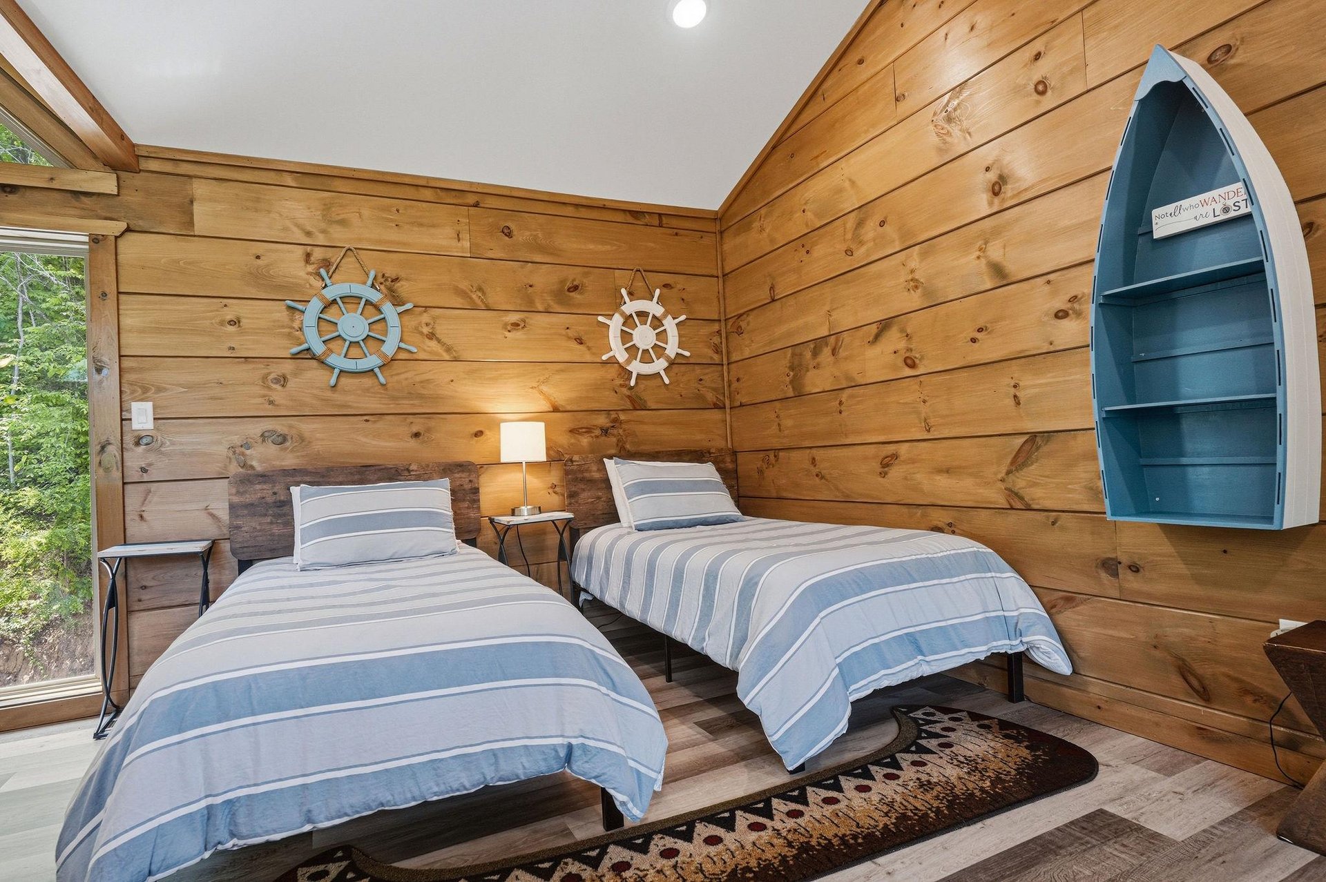 Drift off to sleep in your charming nautical bedroom with cozy twin beds, warm wood walls, and playful maritime touches.
