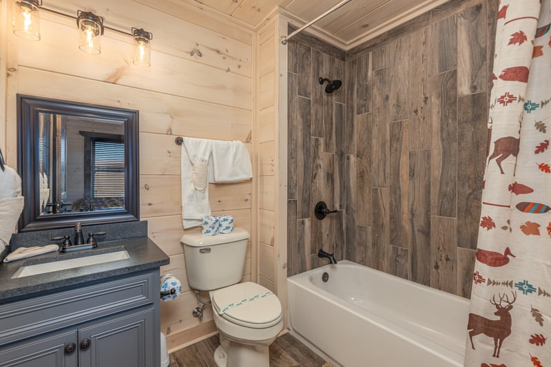 full bathroom with bathtub with wood flooring walls